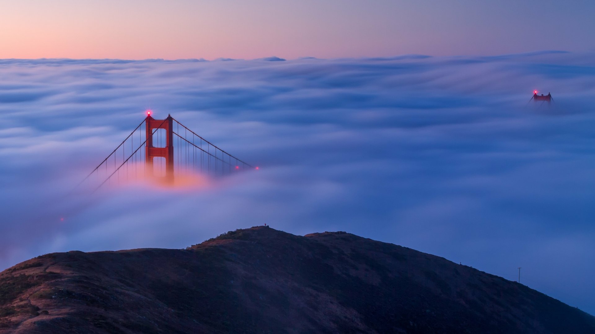 Golden Gate Bridge rising through dense fog at night, captured in stunning 4K Ultra HD quality for a PC desktop wallpaper.