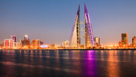 Bahrain World Trade Center towers illuminated at dusk in Manama, reflecting in the water, showcasing the modern skyline and vibrant cityscape. 4K Ultra HD desktop wallpaper.