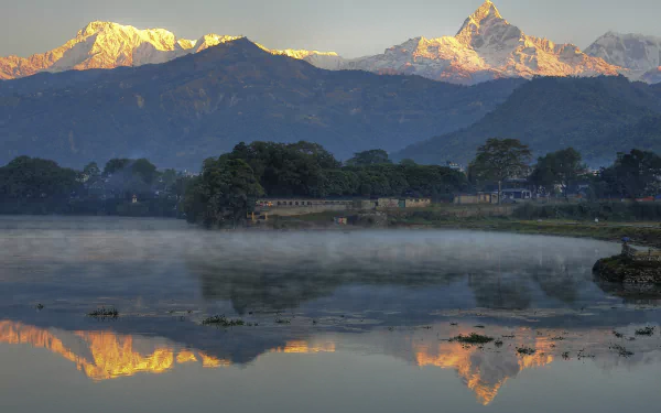 A breathtaking view of Mount Everest and surrounding peaks, with morning mist rising over a tranquil lake, captured in stunning 4K Ultra HD quality, showcasing nature's beauty.