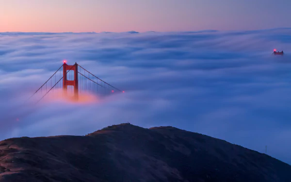 Golden Gate Bridge rising through dense fog at night, captured in stunning 4K Ultra HD quality for a PC desktop wallpaper.