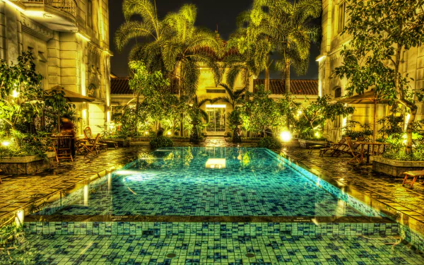 HD image of a luminous, mosaic-tiled pool in Jakarta, Indonesia, surrounded by palm trees and elegant colonial architecture, captured in HDR.