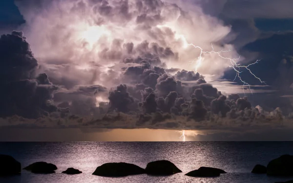 HD photography of a lightning storm illuminating dramatic clouds over a calm sea, captured as a striking PC desktop wallpaper and background.