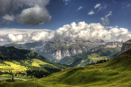HD wallpaper featuring the lush hills and dense forests of the Italian Alps under a cloudy sky.
