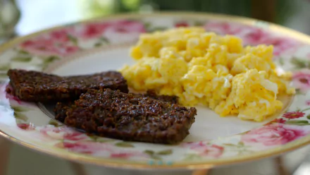 4K Ultra HD PC desktop wallpaper and background of breakfast food: two slices of scrapple with fluffy scrambled eggs on a floral china plate, soft-focus table setting.