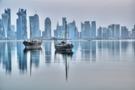 A serene HD desktop wallpaper showing traditional boats on calm waters with the modern skyline of Doha, Qatar, in the background.