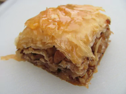 Close-up of syrup-glazed baklava on a white surface, styled as a 2K Quad HD PC desktop wallpaper and background.