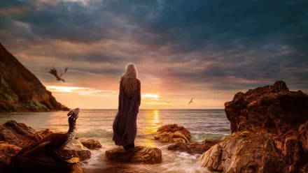 A captivating sunset over the seashore, featuring a figure cloaked in shadow beside a dragon, evoking the epic world of Game of Thrones. A stunning HD wallpaper.