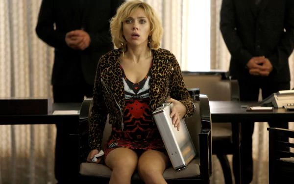 Scarlett Johansson in a scene from the movie Lucy, holding a briefcase and looking startled, featured in a 4K Ultra HD PC desktop wallpaper.