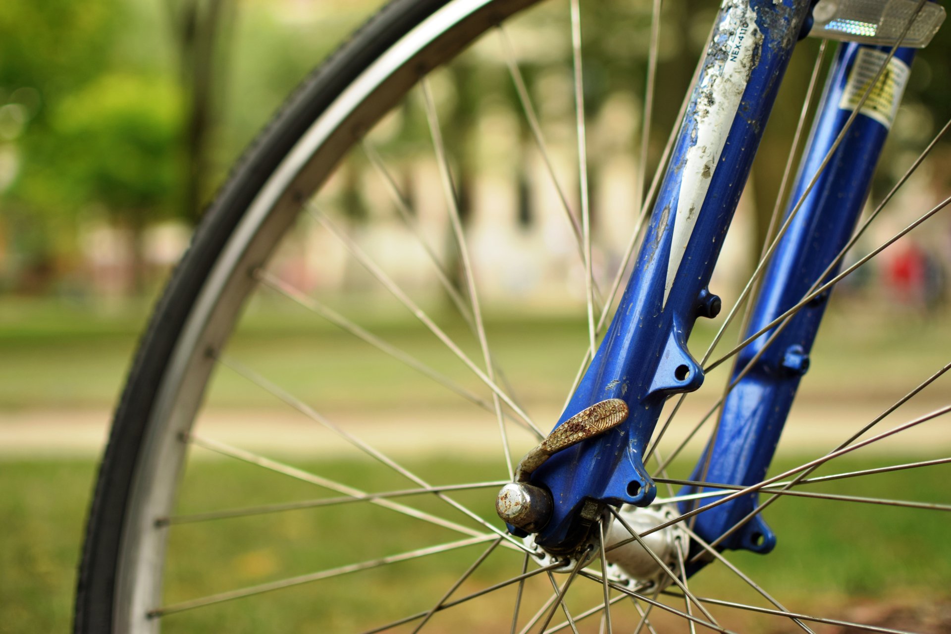 Close-up of a blue bicycle wheel and fork, captured in sharp detail for a 4K Ultra HD PC desktop wallpaper featuring a vehicle.