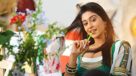 Brunette Indian Bollywood actress Regina Cassandra poses with a playful expression in a vibrant 4K Ultra HD desktop wallpaper background.