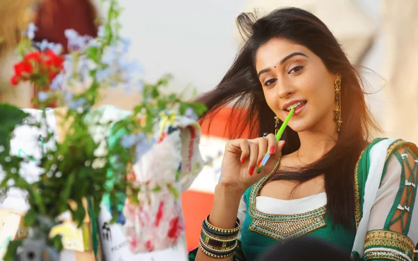 Brunette Indian Bollywood actress Regina Cassandra poses with a playful expression in a vibrant 4K Ultra HD desktop wallpaper background.