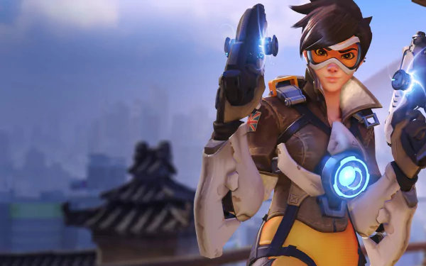 HD desktop wallpaper featuring Tracer from the video game Overwatch, depicted in an action pose with a blurry cityscape in the background.