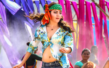 An HD desktop wallpaper featuring Indian actress Samantha Akkineni, a Brunette Bollywood celebrity, wearing a colorful outfit and headband, set against a vibrant background with purple and pink fabric.