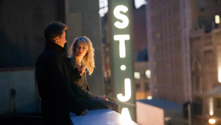 A scene from the movie Birdman, featuring Edward Norton and Emma Stone on a rooftop at night, illuminated by city lights and the glowing ST. J sign in the background.
