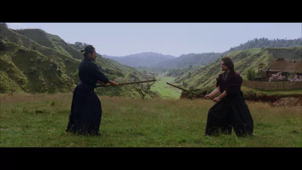 Two warriors face off with swords in a lush, green landscape, capturing a dramatic moment from the movie The Last Samurai. This HD image serves as an engaging desktop wallpaper.