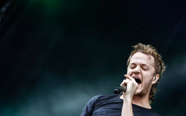 A dynamic 4K Ultra HD wallpaper featuring a performer passionately singing on stage, representing the energy and spirit of Imagine Dragons.