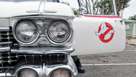 HD PC desktop wallpaper of Ecto‑1 from the movie Ghostbusters — chrome grille and headlights with the Ghostbusters logo on an open car door.