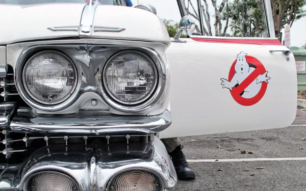 HD PC desktop wallpaper of Ecto‑1 from the movie Ghostbusters — chrome grille and headlights with the Ghostbusters logo on an open car door.