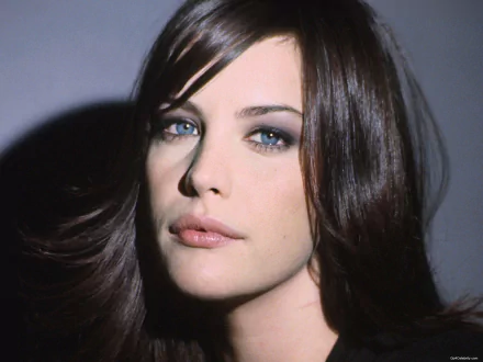 HD PC desktop wallpaper — close-up celebrity portrait of an unidentified woman with dark hair and blue-gray eyes, soft lighting on a neutral gray background.