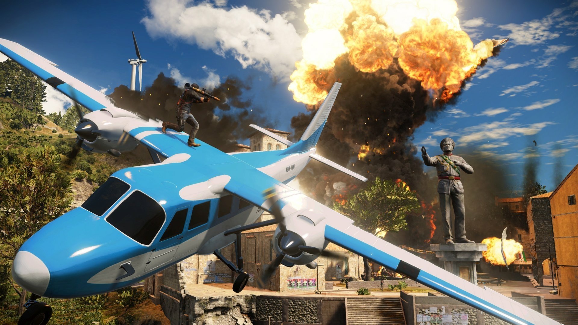 HD PC desktop wallpaper featuring an intense explosion scene from the video game Just Cause 3, with a blue and white plane in mid-flight against a bright sky.