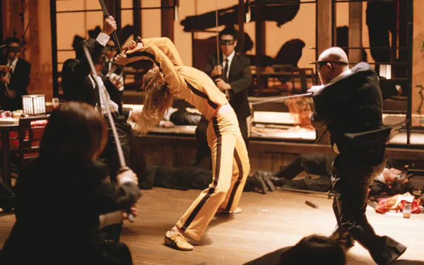 HD PC desktop wallpaper featuring an intense fight scene from the movie Kill Bill: Vol. 1, showcasing the Bride in her iconic yellow outfit.