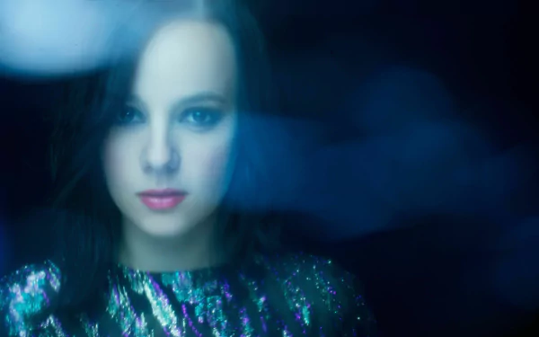 4K Ultra HD PC desktop wallpaper — soft-focus portrait of a female pop singer in blue light, wearing a sequined top and gazing at the viewer.