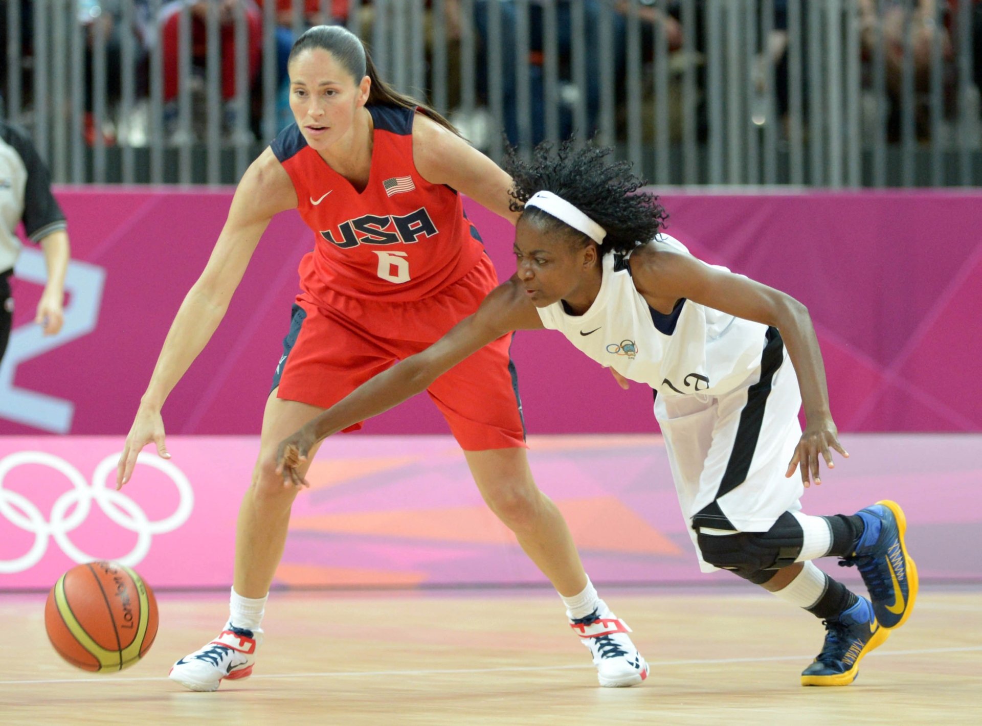 Two female basketball players compete for the ball during a match, showcasing intense sportsmanship. This 4K Ultra HD image serves as a dynamic PC desktop wallpaper.