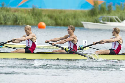 Rowing, Sports — 4K Ultra HD PC desktop wallpaper: three rowers in a yellow shell power through water, oars splashing past an orange buoy and a spectator boat.