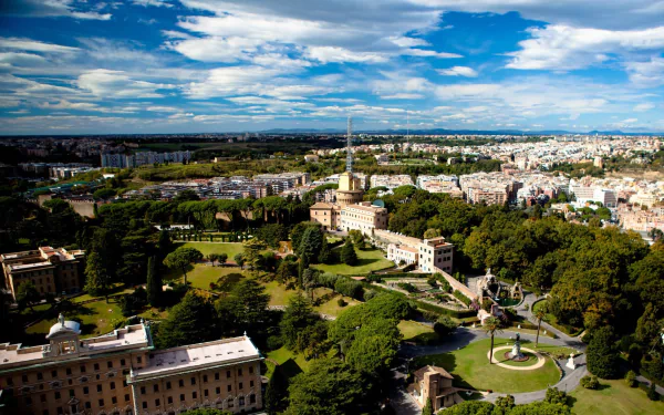 A stunning HD desktop wallpaper showcasing a panoramic view of Rome's vibrant cityscape and lush parks, blending natural beauty with man-made architecture under a blue sky.