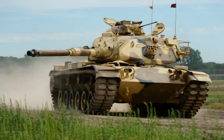 HD desktop wallpaper featuring a military M60 Patton tank advancing across a grassy field under a clear sky.