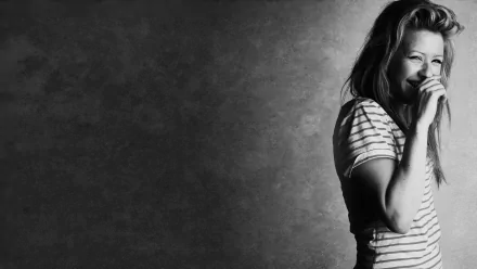 Black and white wallpaper featuring a smiling woman in a striped shirt, capturing the essence of music and vibrancy associated with Ellie Goulding. 