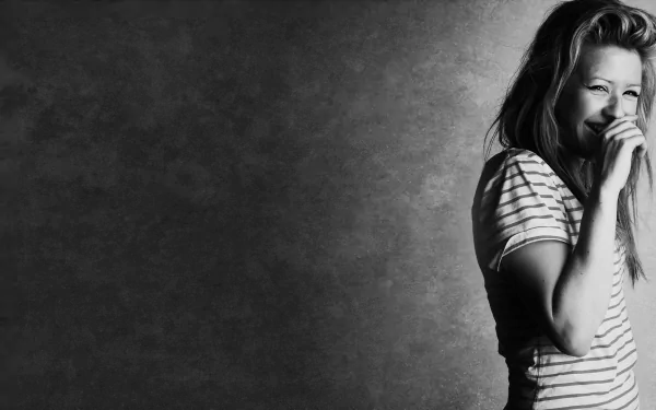 Black and white wallpaper featuring a smiling woman in a striped shirt, capturing the essence of music and vibrancy associated with Ellie Goulding. 