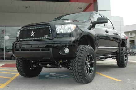 HD desktop wallpaper featuring a black Toyota Tundra with off-road tires, parked outside, showcasing rugged vehicle design inspired by Jeep aesthetics.