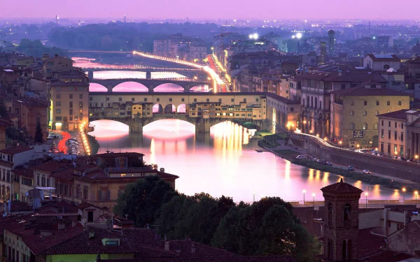 HD desktop wallpaper showcasing the illuminated Ponte Vecchio bridge and cityscape of Florence at dusk, highlighting the beauty of this man-made landmark.