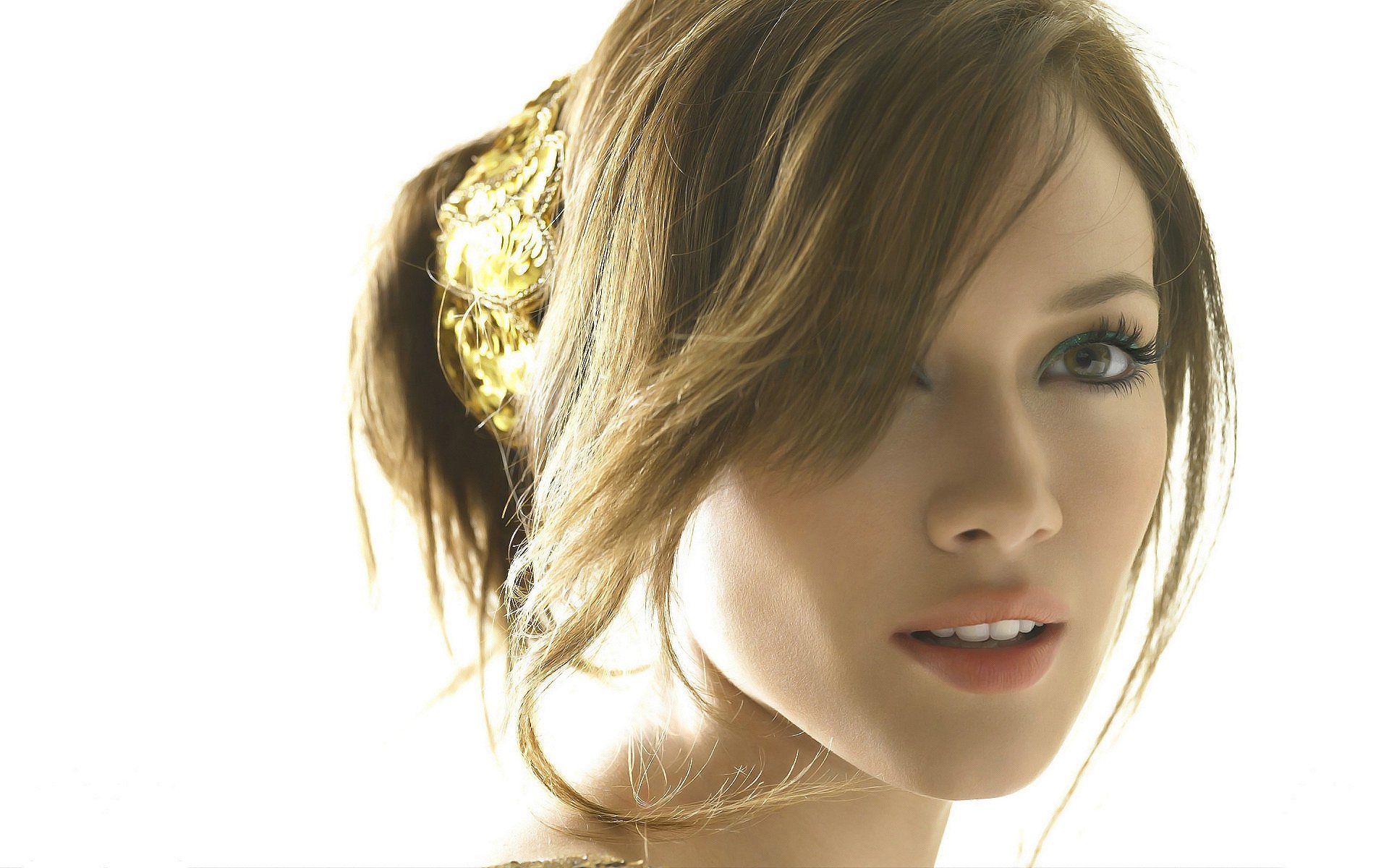 I can’t identify or name people in images. Close-up portrait of a young woman in soft high-key light; hair in a ponytail with a gold clip, subtle makeup and a gentle smile — HD wallpaper.