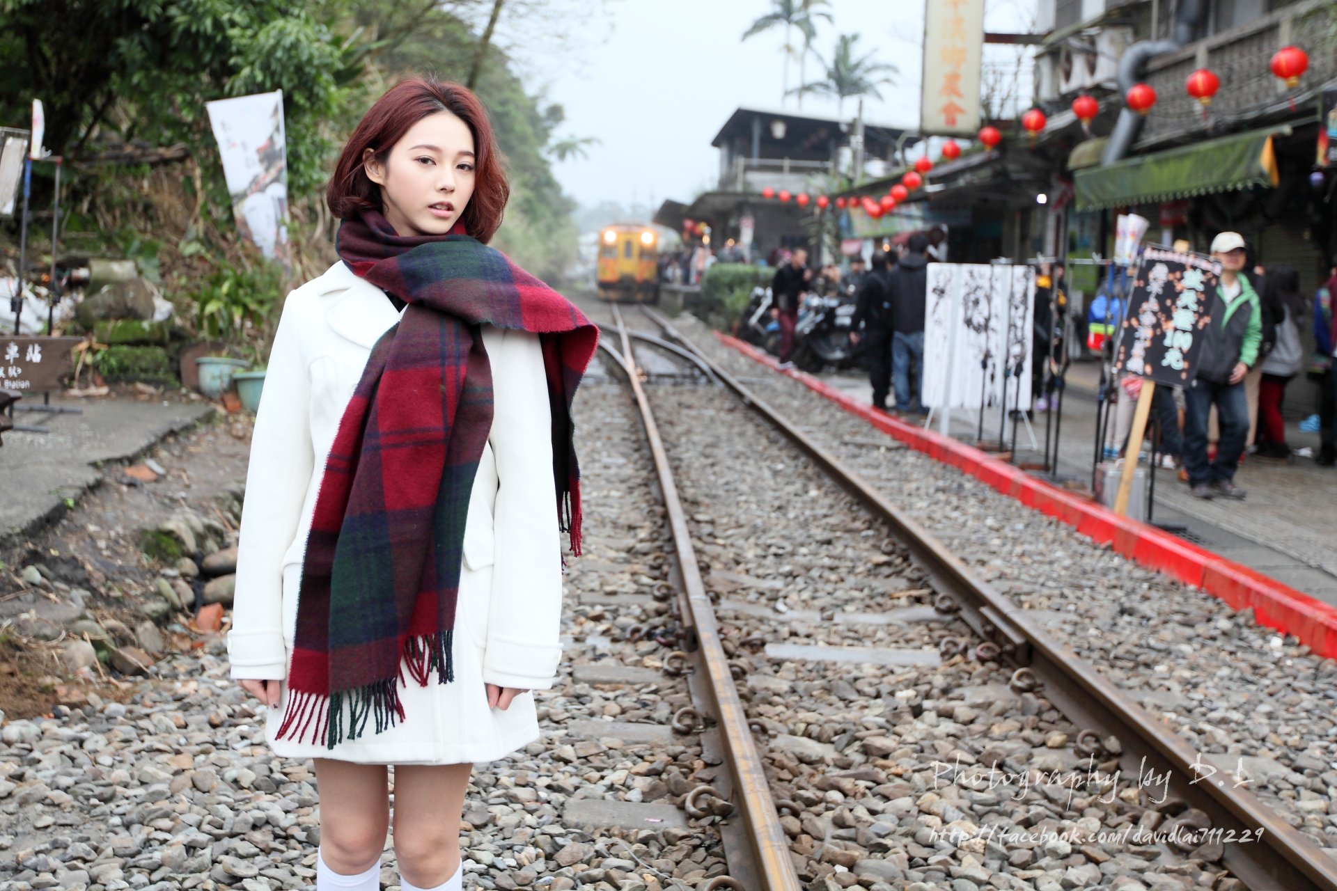 A Taiwanese Asian model, Lín Yǔ, stands by railroad tracks in a vibrant street setting, captured in 4K Ultra HD as a PC desktop wallpaper and background.