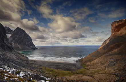 A stunning seascape of Kvalvika Beach in the Lofoten Islands, Norway, showcasing dramatic cliffs, gentle waves, and a vibrant sky, captured in rich 4K Ultra HD detail.