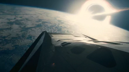 A stunning HD desktop wallpaper from the movie Interstellar, showcasing a spacecraft overlooking Earth with a striking black hole in the background.