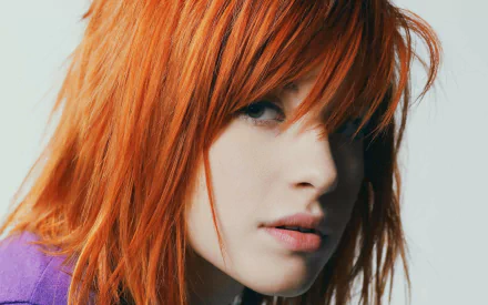 HD PC desktop wallpaper featuring a close-up portrait of Hayley Williams with vibrant red hair, capturing her intense gaze and musical persona.