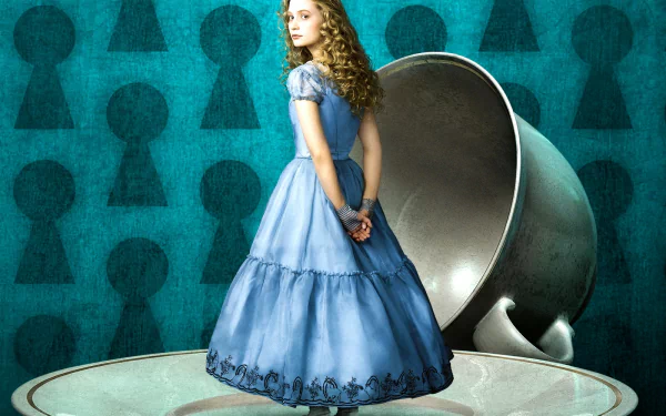 HD desktop wallpaper featuring Alice in a blue dress from the 2010 movie Alice in Wonderland, standing beside a large silver teacup against a keyhole-patterned background.