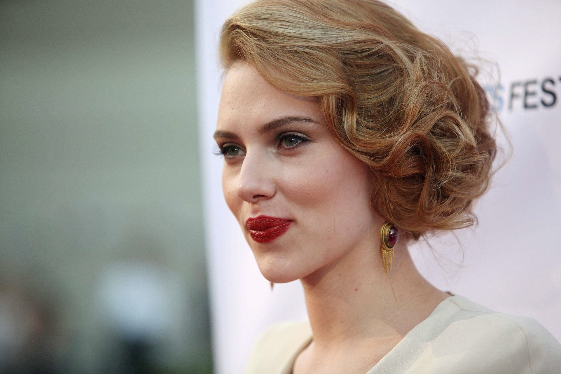 HD desktop wallpaper featuring a close-up portrait of celebrity Scarlett Johansson with styled hair and bold red lipstick at a red carpet event.