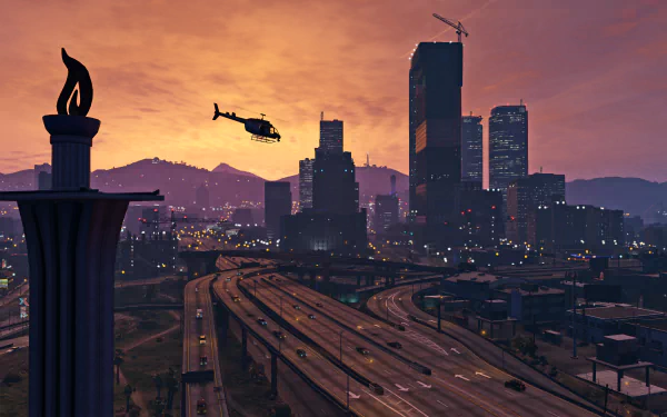 A stunning HD wallpaper from Grand Theft Auto V featuring a helicopter flying over a vibrant city skyline at sunset, with illuminated buildings and a winding highway below.
