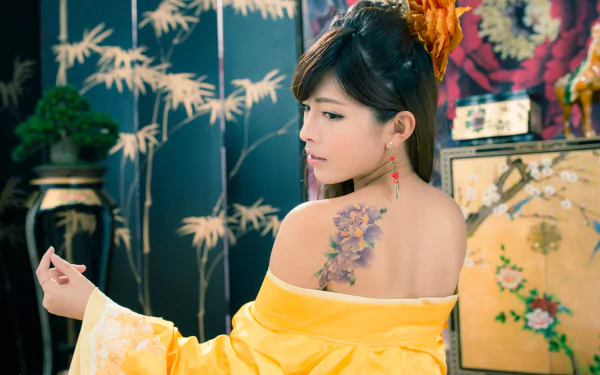 5K Ultra HD desktop wallpaper: portrait of a Taiwanese Asian woman in a yellow traditional costume with ornate hair-dress and dangling earrings, revealing a floral shoulder tattoo.