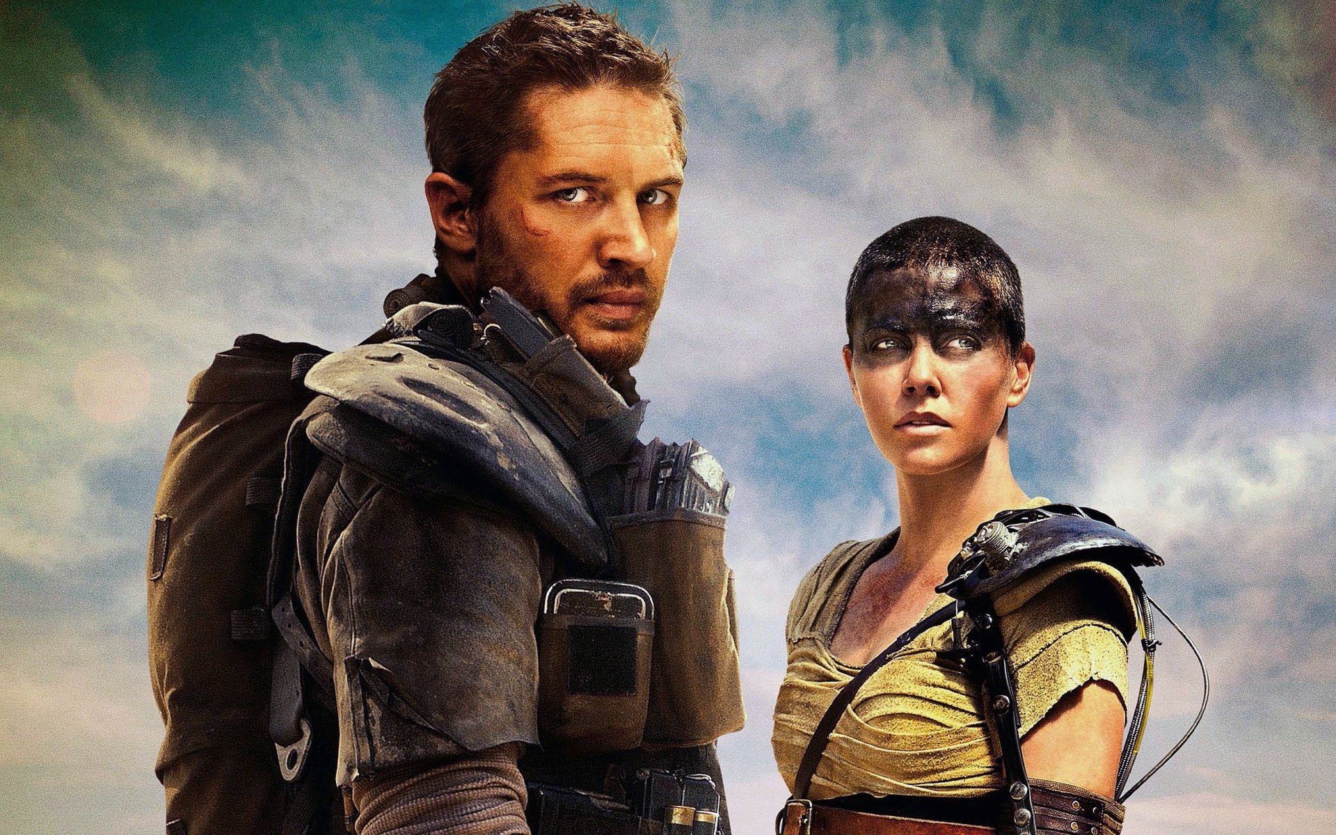 HD wallpaper featuring Imperator Furiosa and Max Rockatansky from the film *Mad Max: Fury Road*, showcasing their intense expressions against a dramatic sky.