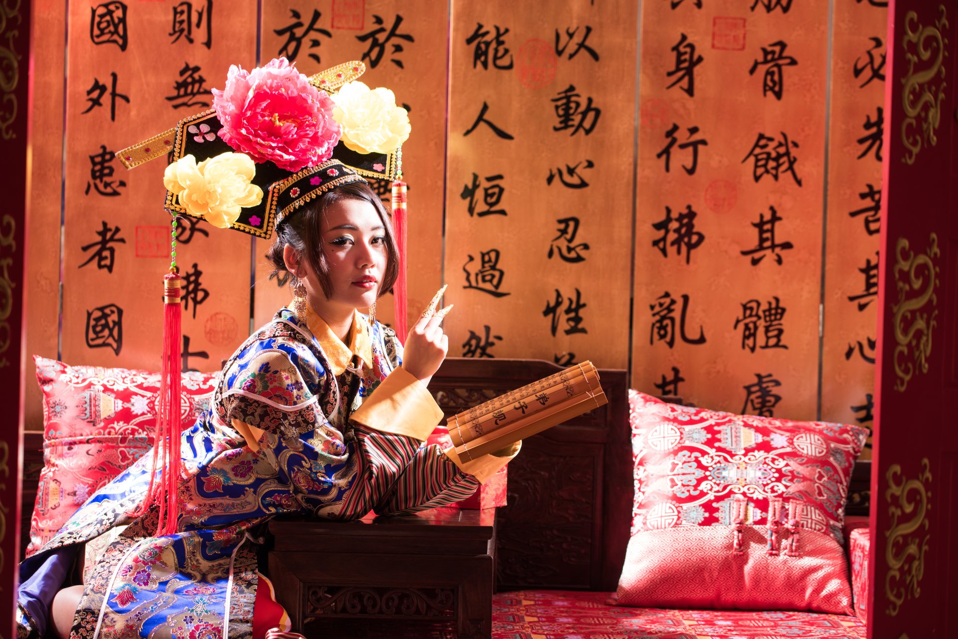 A Taiwanese woman dressed in traditional Chinese costume, holding a scroll, posed against a backdrop of calligraphy in a 4K Ultra HD desktop wallpaper.