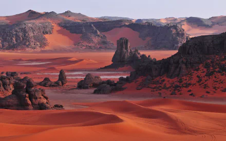 Stunning HD image of the Sahara Desert in Algeria, featuring the unique rock formations of Tassili N'Ajjer amidst vibrant red sands and serene dunes.