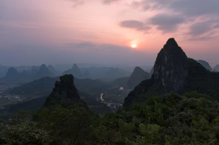 A stunning sunset over the mountains of Guangxi Zhuang, China, captured in vibrant detail. This landscape photo highlights the natural beauty of spring in 4K Ultra HD.