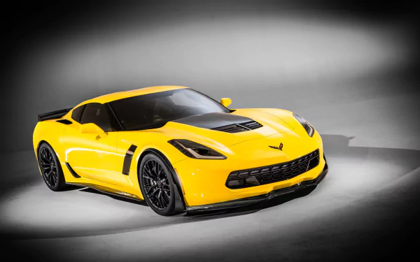 A vibrant yellow Chevrolet Corvette Z06 sports car showcased against a dark gray background, featured as a high-definition PC desktop wallpaper.