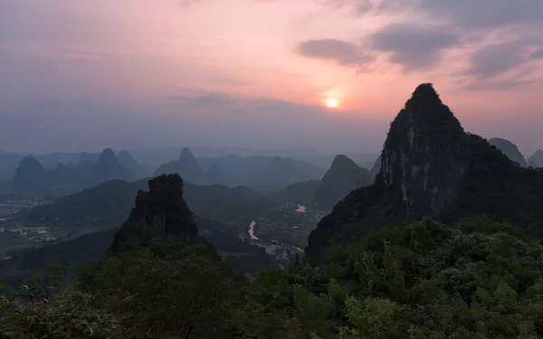 A stunning sunset over the mountains of Guangxi Zhuang, China, captured in vibrant detail. This landscape photo highlights the natural beauty of spring in 4K Ultra HD.