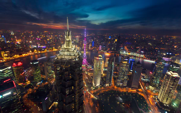 Aerial view of Shanghai at night, showcasing its stunning architectural landscape illuminated by vibrant city lights, capturing the dynamic essence of this modern metropolis.